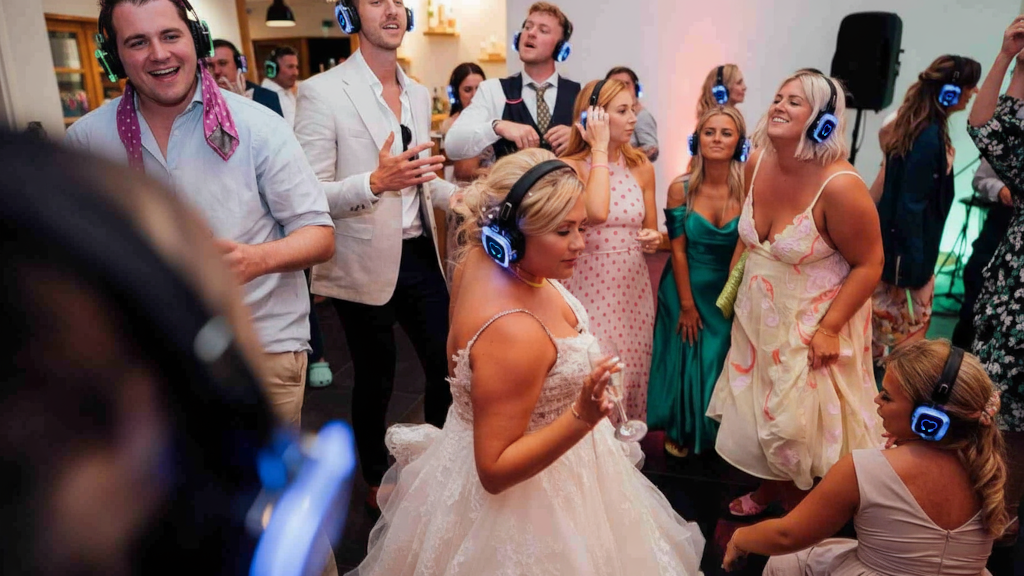 Gasten dansen met verlichte koptelefoons op een silent disco bruiloft in Gelderland.